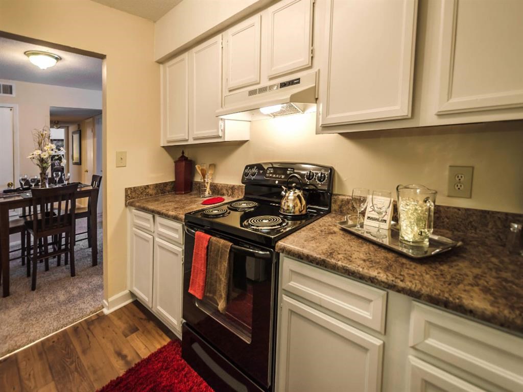 a kitchen with white cabinets and a black stove