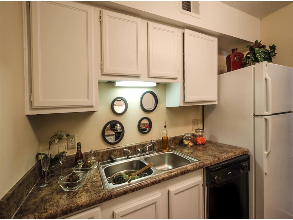 a kitchen with white cabinets and a sink and a refrigerator