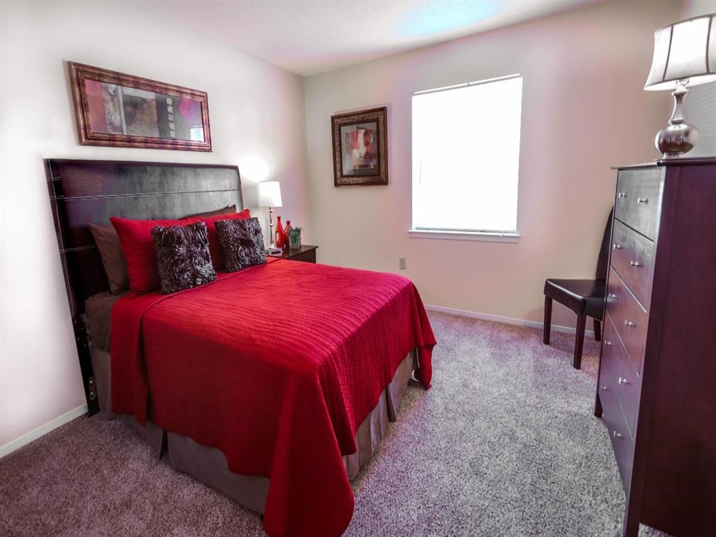 a bedroom with a bed and a dresser and a window