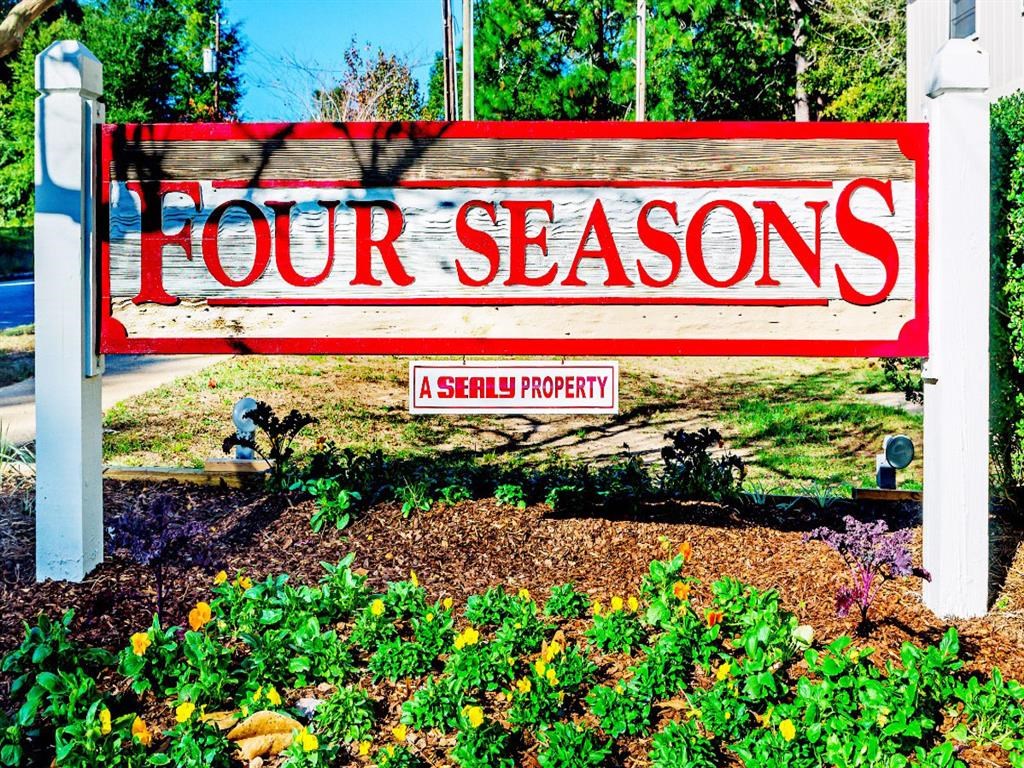 a sign that says four seasons in front of a garden