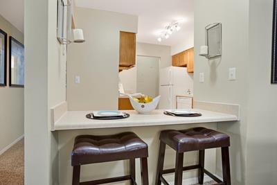 a kitchen with a counter and three bar stools