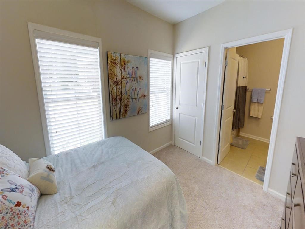 a bedroom with a bed and a door to a bathroom