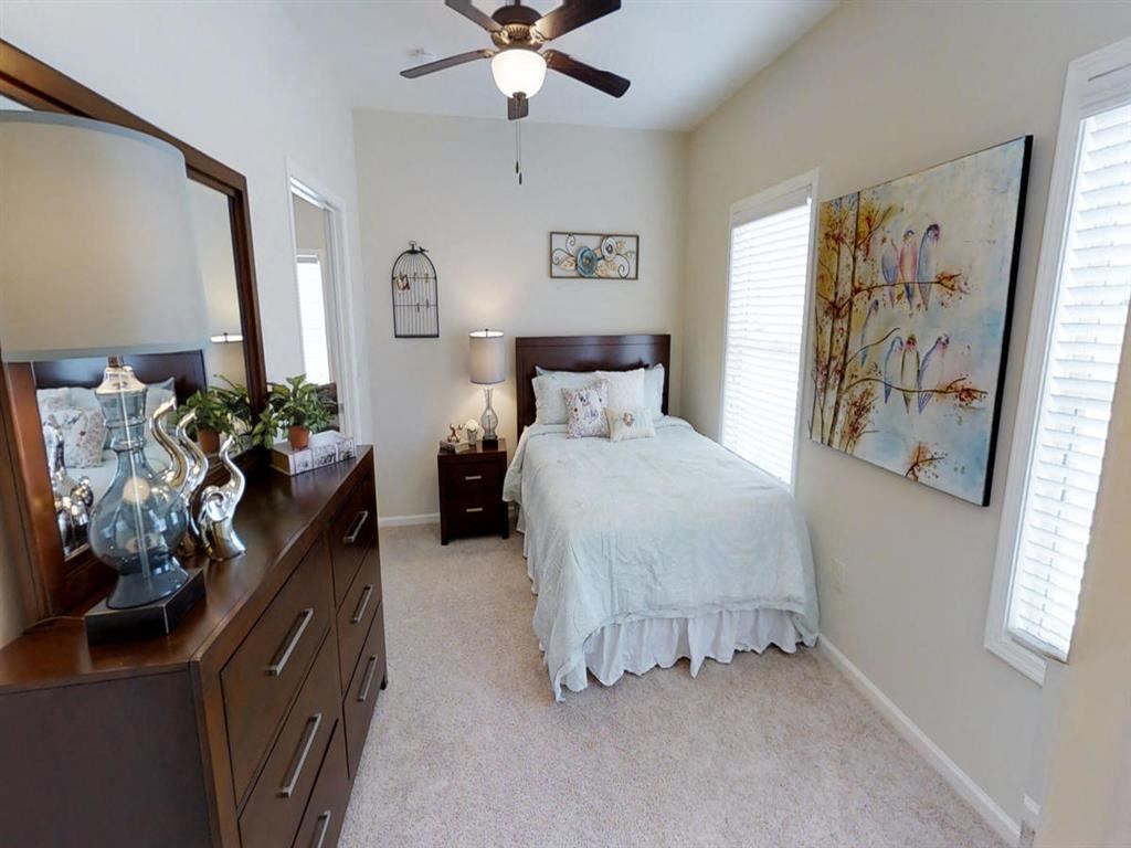 a bedroom with a bed and a ceiling fan