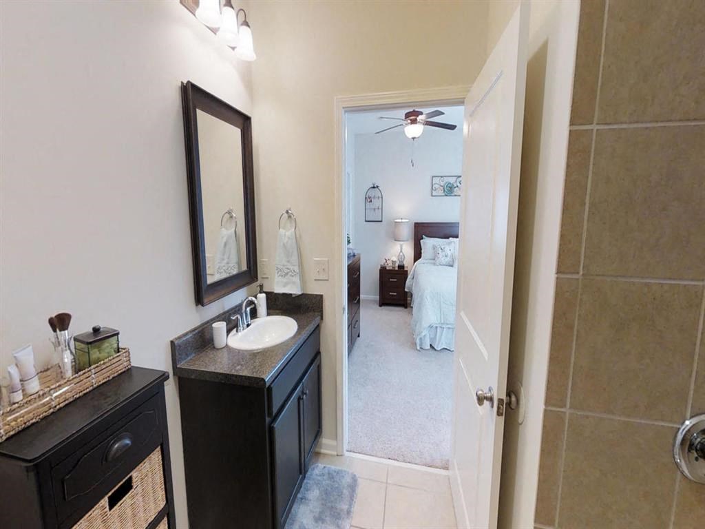 a bathroom with a sink and a mirror and a bedroom