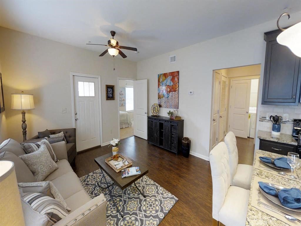 a living room with furniture and a ceiling fan