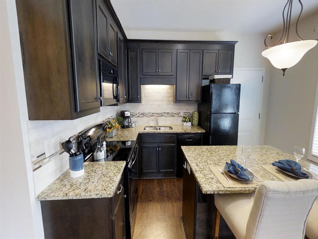 a kitchen with black appliances and granite counter tops