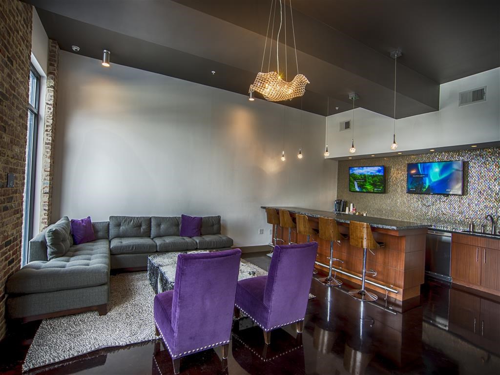 a living room with purple chairs and a bar
