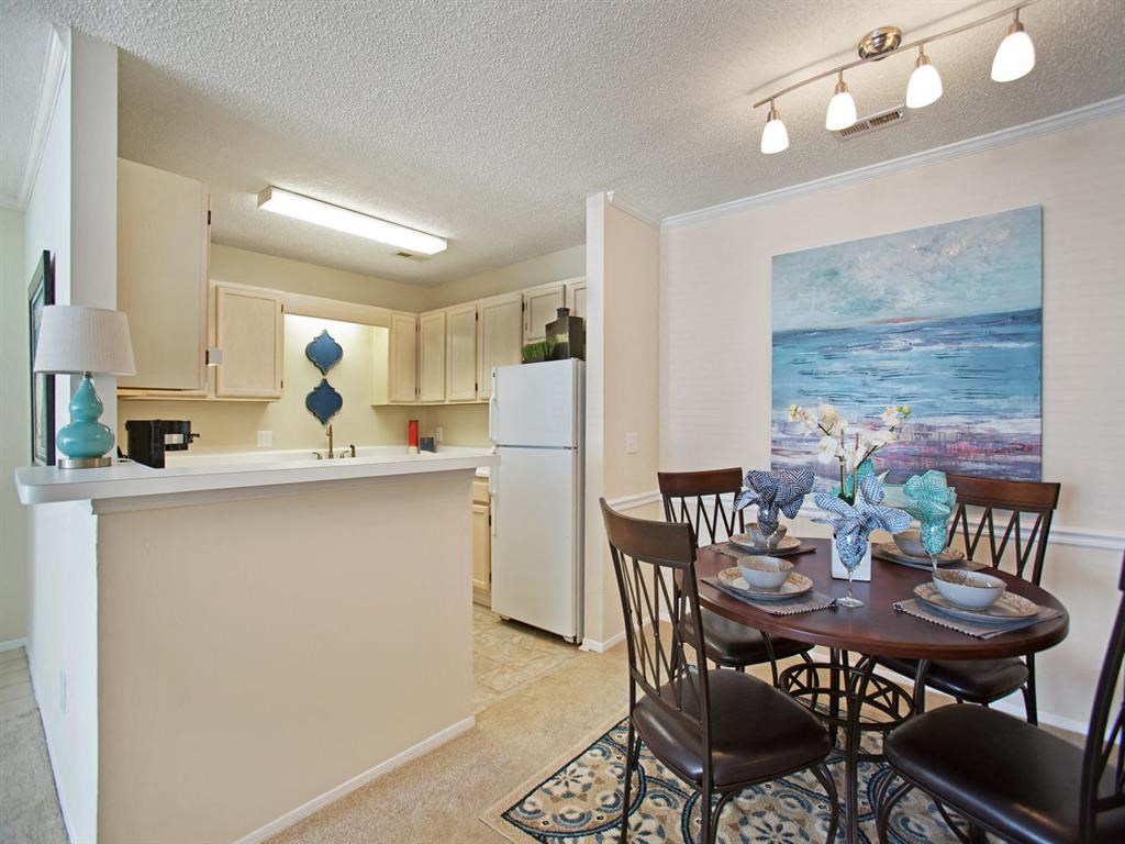 a dining room and kitchen with a table and chairs