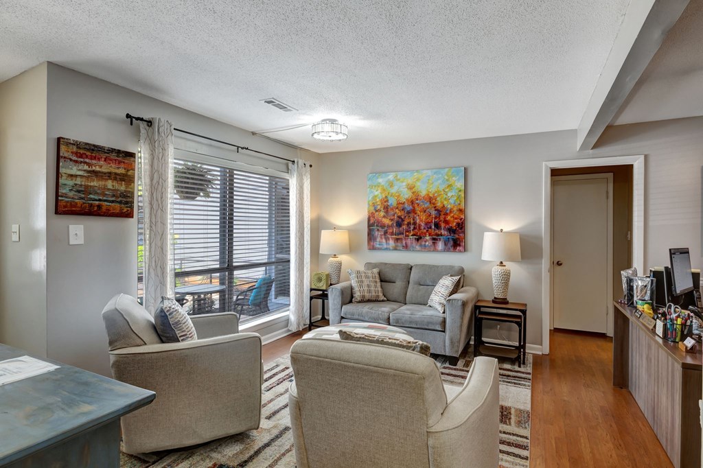 a living room with couches and chairs and a large window