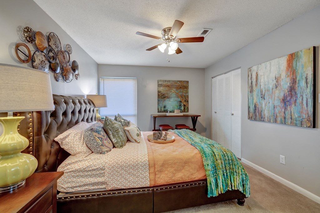 a bedroom with a bed and a ceiling fan