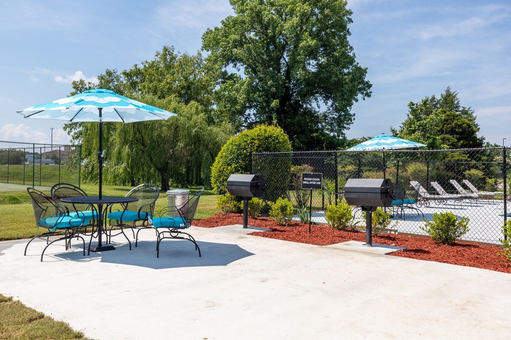 a patio with chairs tables and umbrellas and a pool