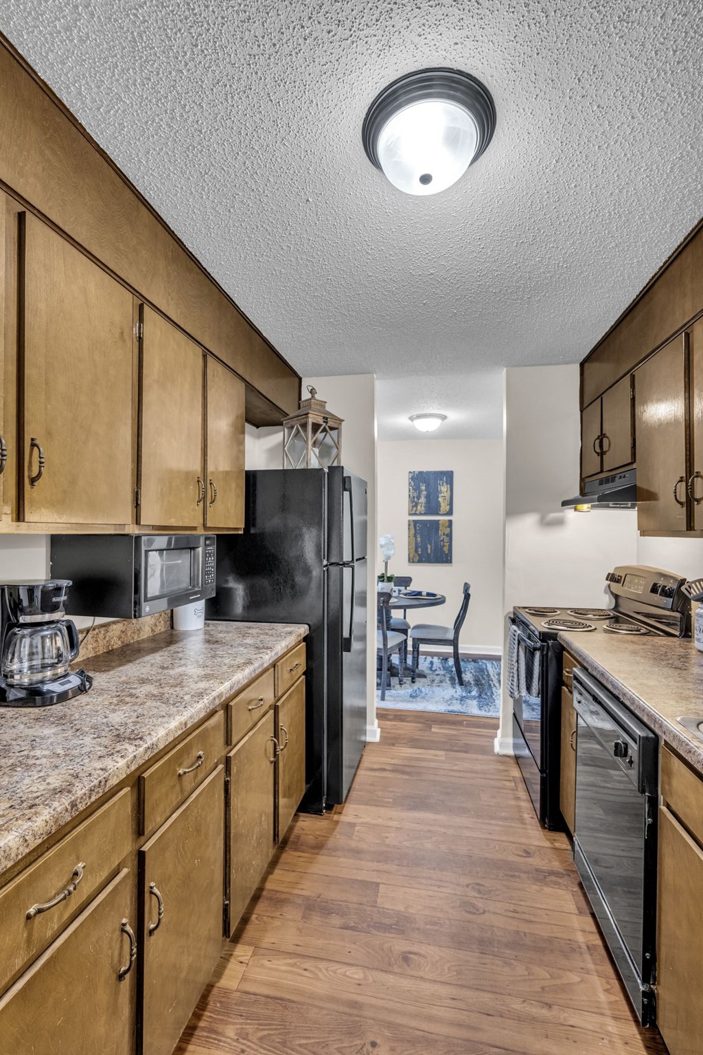 full kitchen with granite counters and appliances and a dining room with a table and chairs