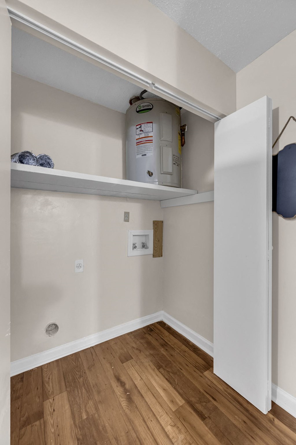 a room with a water heater and a shelf on the wall