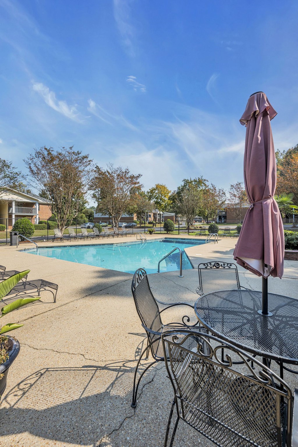 a swimming pool with tables and chairs and a umbrella