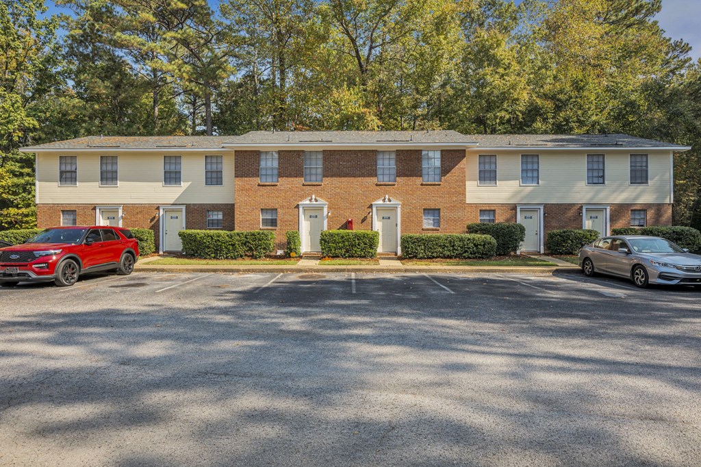 a brick apartment building with cars parked in front of it
