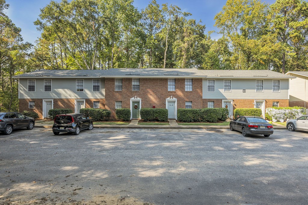a brick apartment building with cars parked in front of it