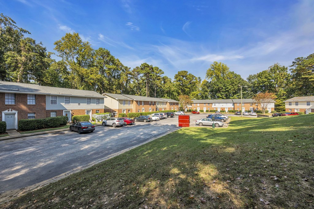a parking lot with cars in front of an apartment building