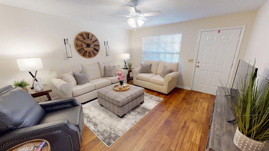a living room with furniture and a ceiling fan