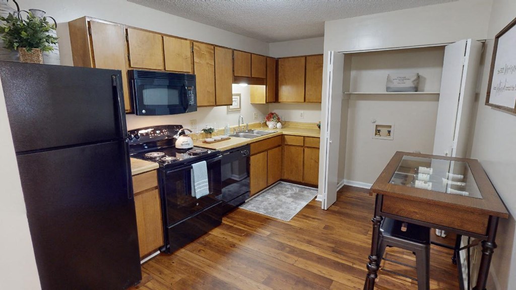 a kitchen with black appliances and wooden cabinets