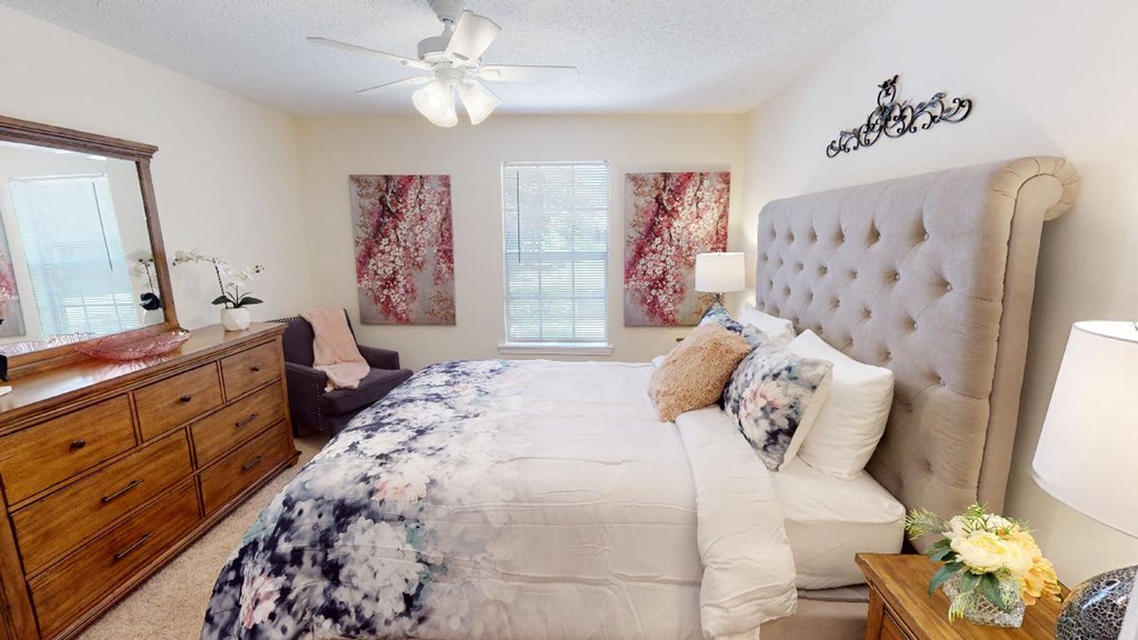 a bedroom with a large bed and a ceiling fan