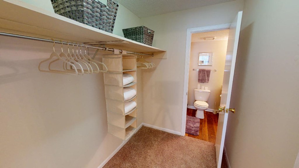 a walk in closet in a bathroom with a toilet