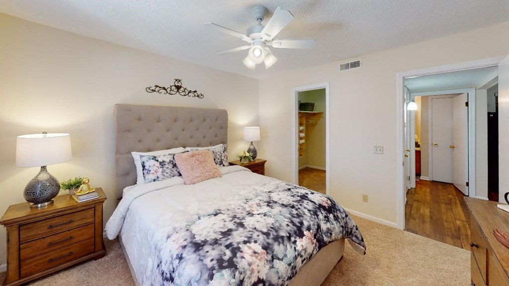 a bedroom with a bed and a ceiling fan