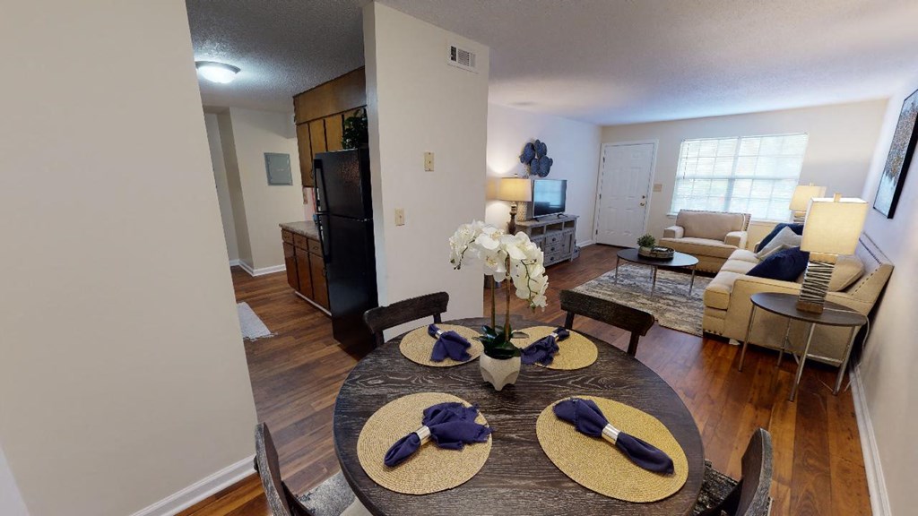 a living room and dining room with a table and chairs