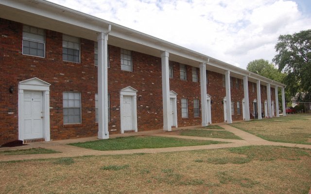 A long row of red brick houses with white doors and windows.