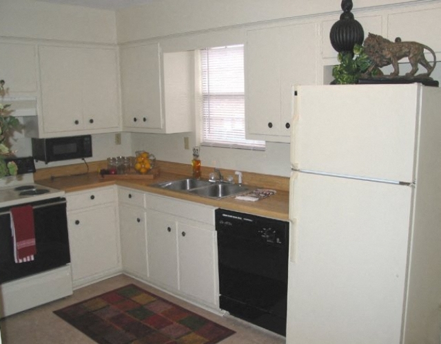 A kitchen with white cabinets and a black oven.