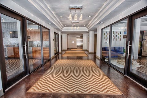 a lobby with a checkered rug and glass doors