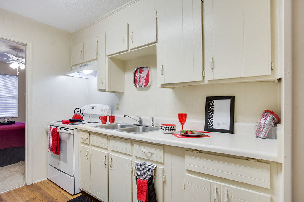 a kitchen with white cabinets and white appliances and a sink