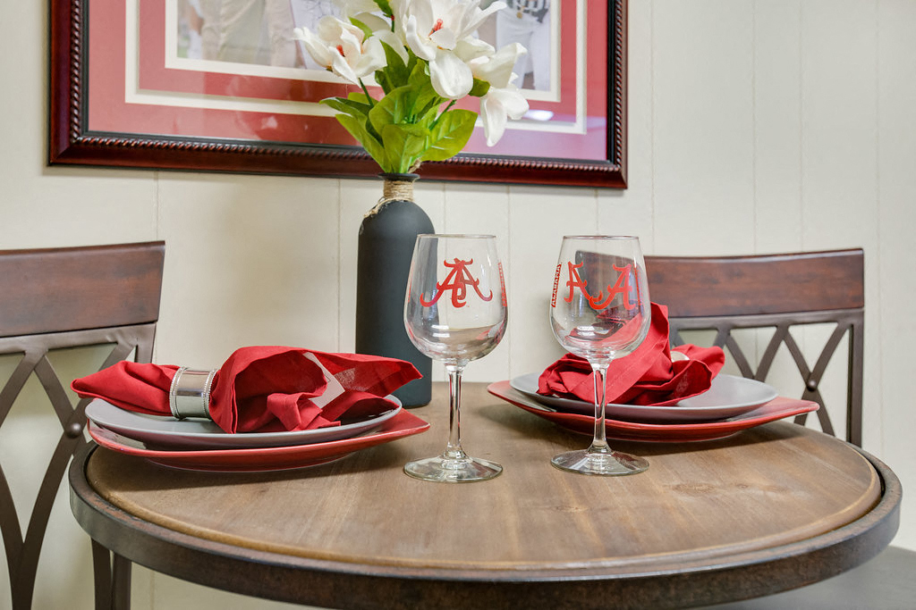 a table with plates and wine glasses and a vase of flowers
