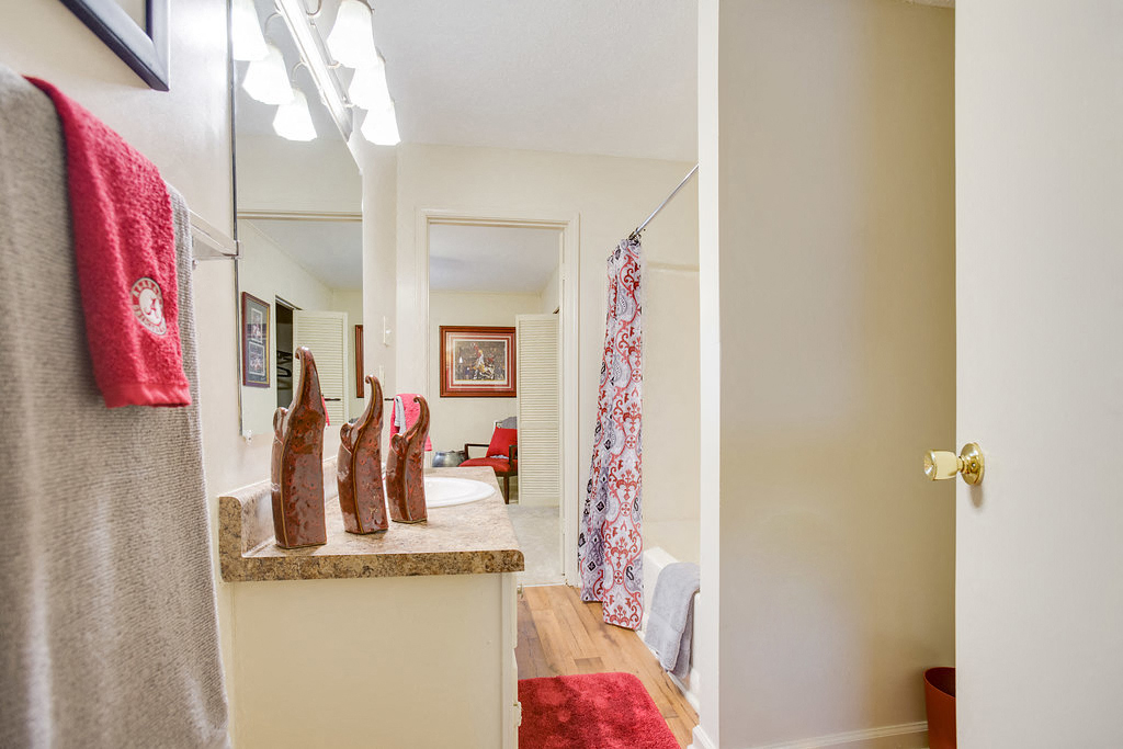 a dressing room with shoes on a counter and a bathroom with a shower