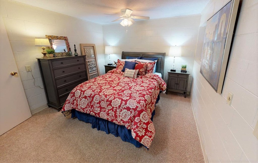 a bedroom with a bed and a ceiling fan