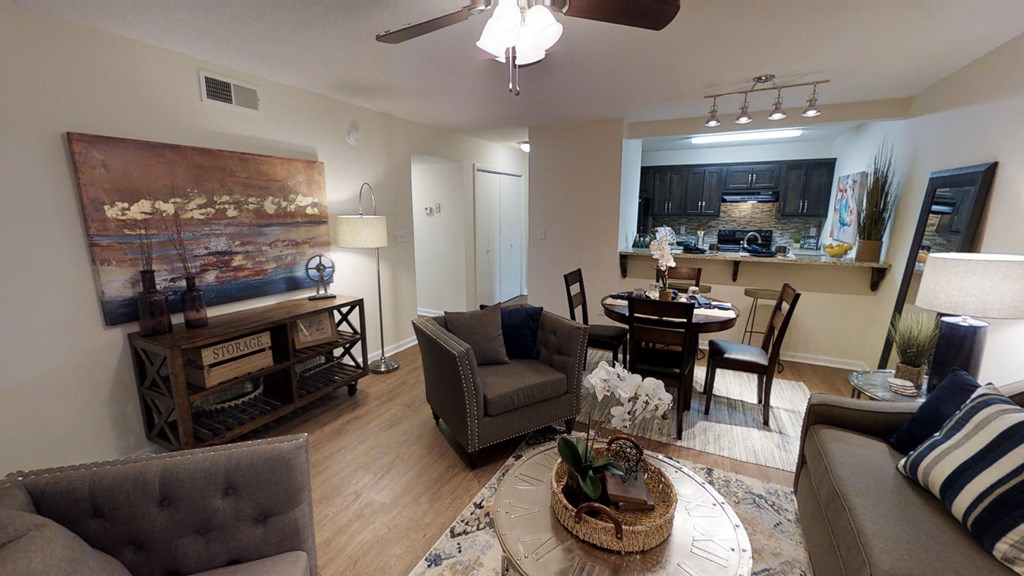 a living room with couches and chairs and a dining room table