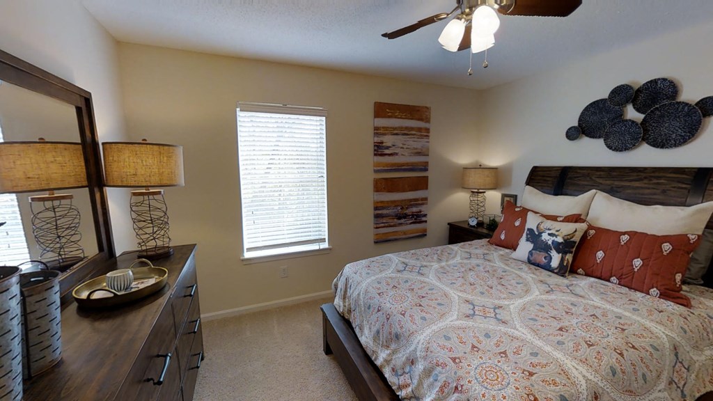 a bedroom with a large bed and a ceiling fan