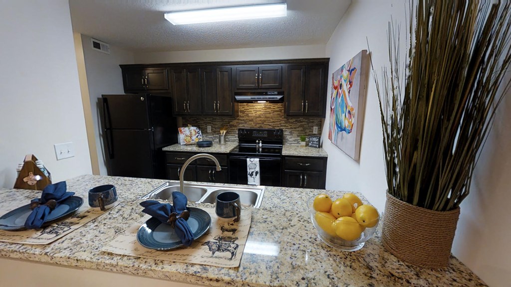 a kitchen with black appliances and granite counter tops