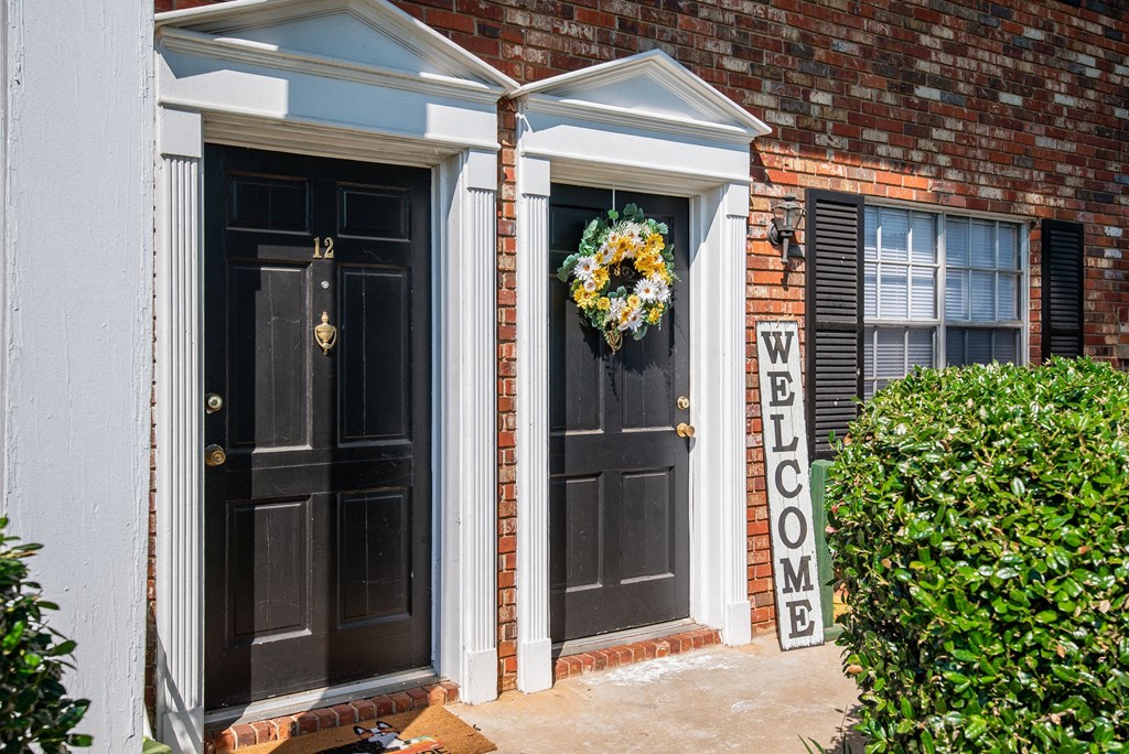 a home with two black doors and a wreath on the door
