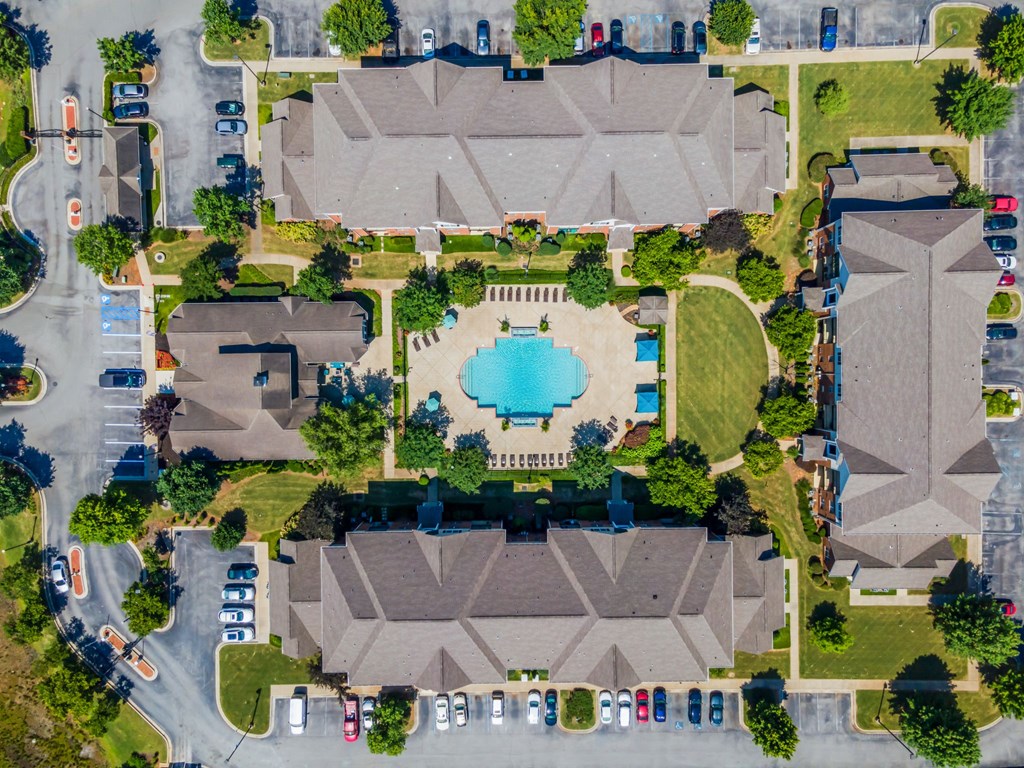 an aerial view of a parking lot with a pool in the middle