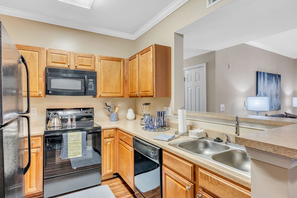 a kitchen with wooden cabinets and appliances and a sink