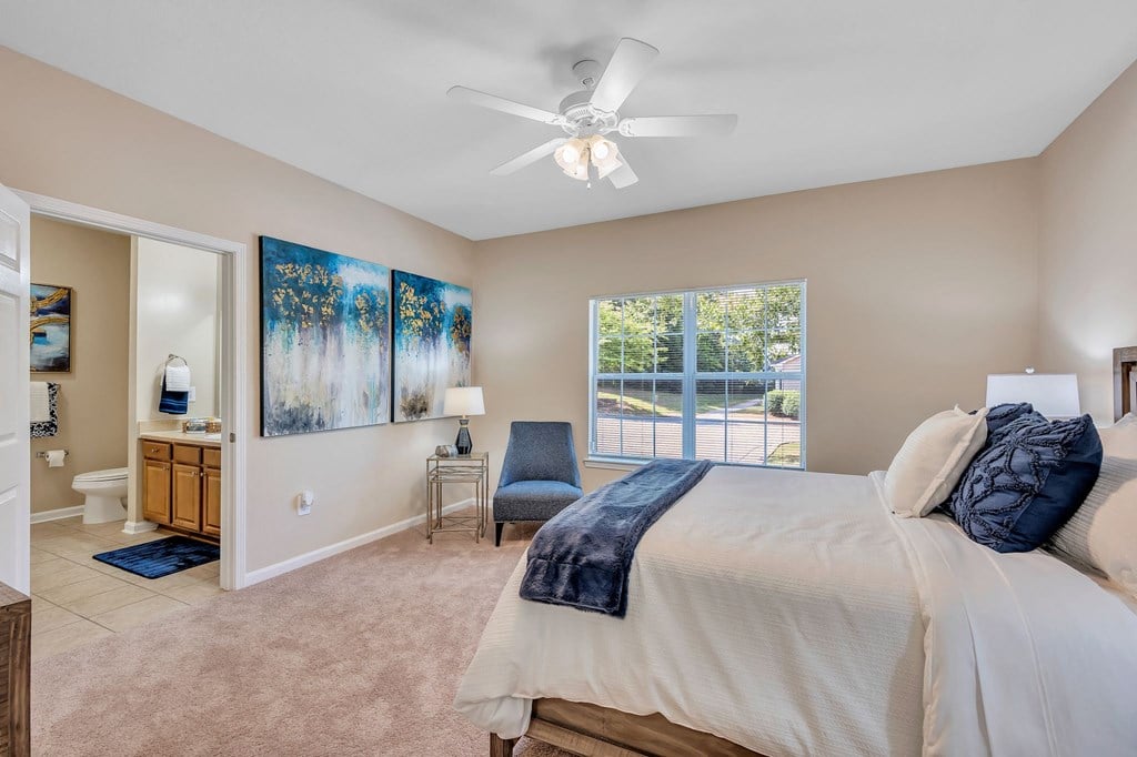 a bedroom with a large bed and a ceiling fan