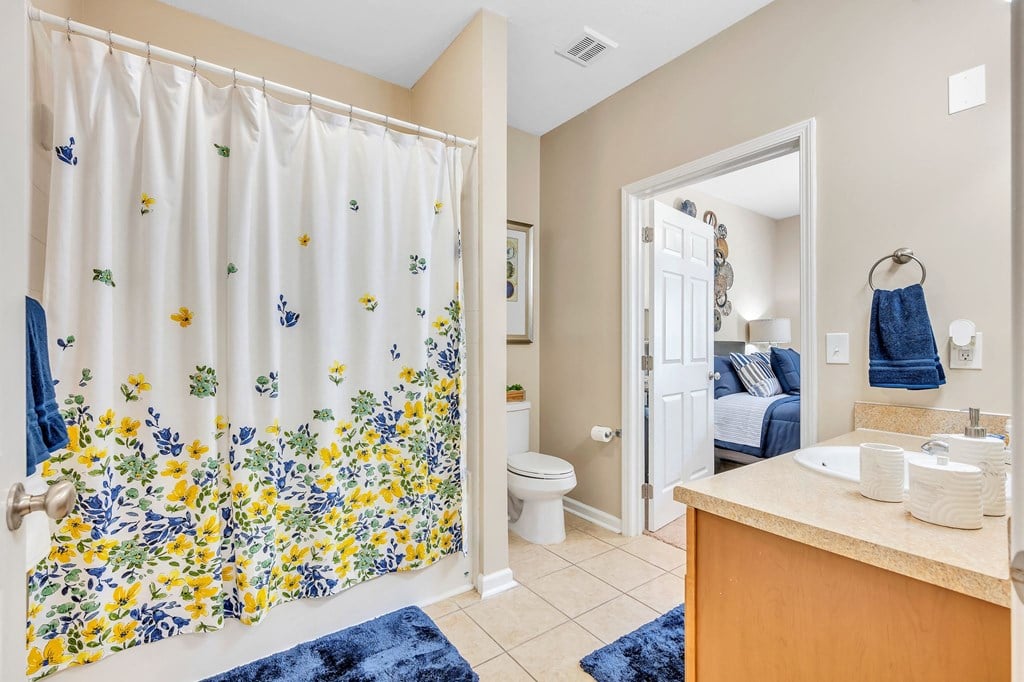 a bathroom with a shower curtain and a sink and a toilet
