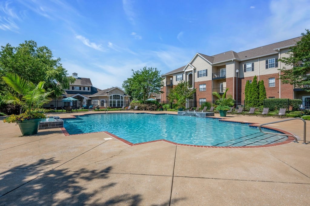 a swimming pool with an apartment building in the background