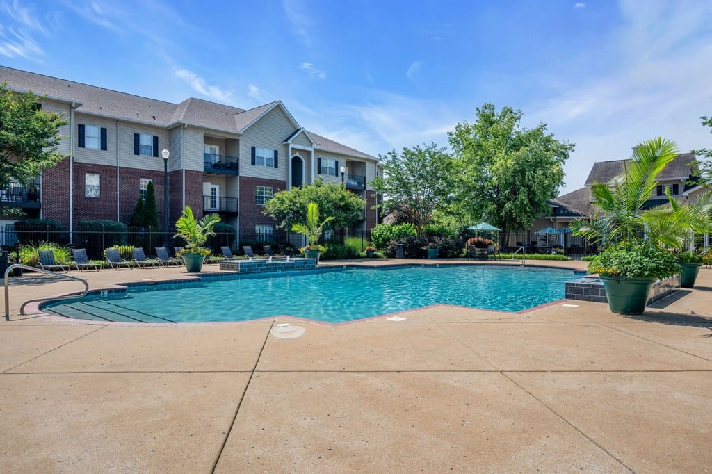 a swimming pool with an apartment building in the background