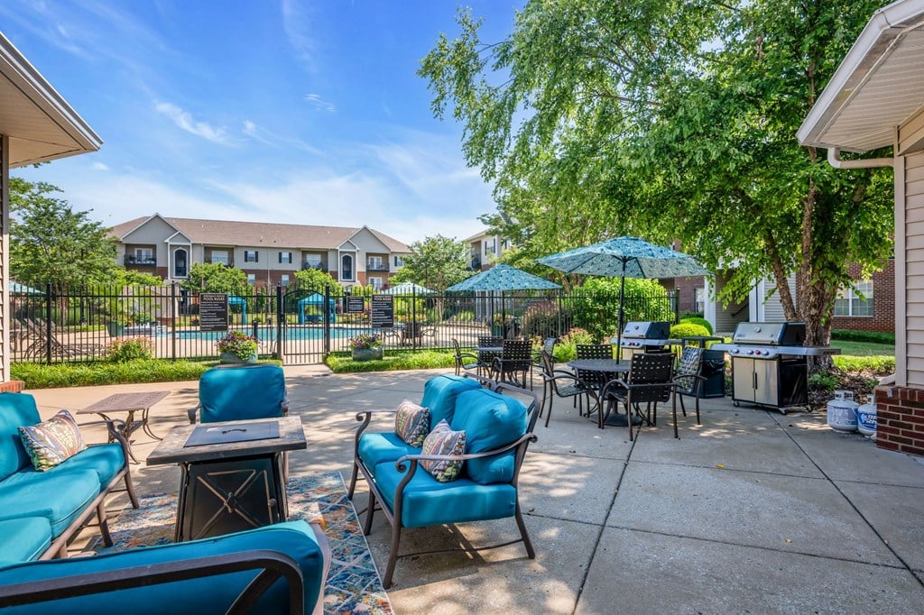 a patio with blue chairs and tables and umbrellas