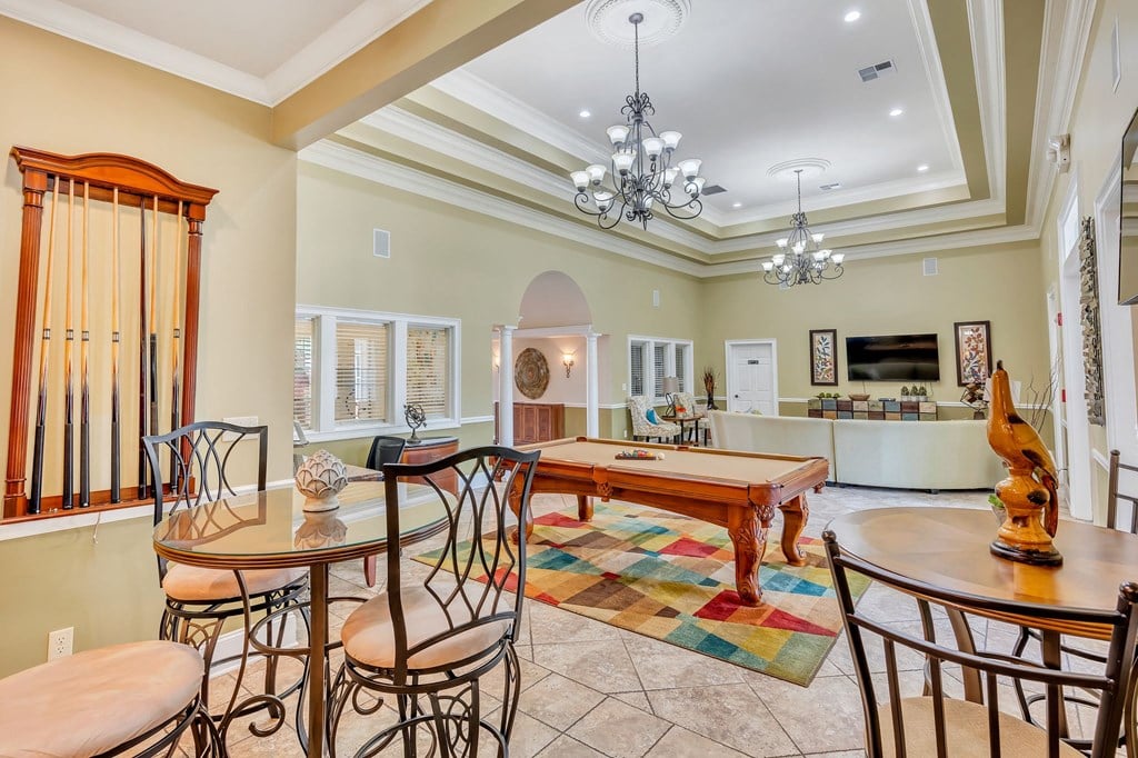 a game room with a pool table and tables