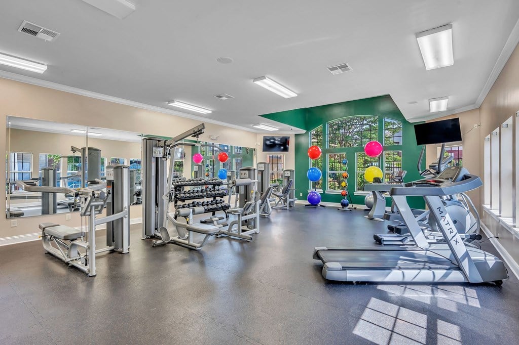 a gym with weights and other equipment and a colorful wall