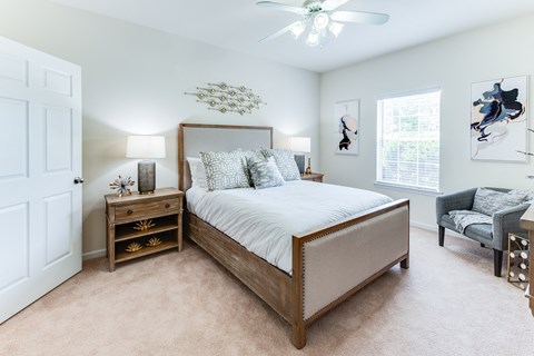 a bedroom with a large bed and a ceiling fan