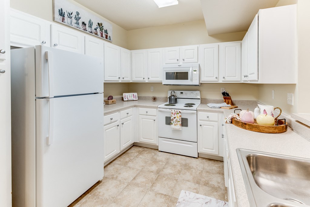 a white kitchen with white appliances and white cabinets