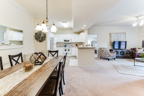 a living room with a dining room table and a kitchen
